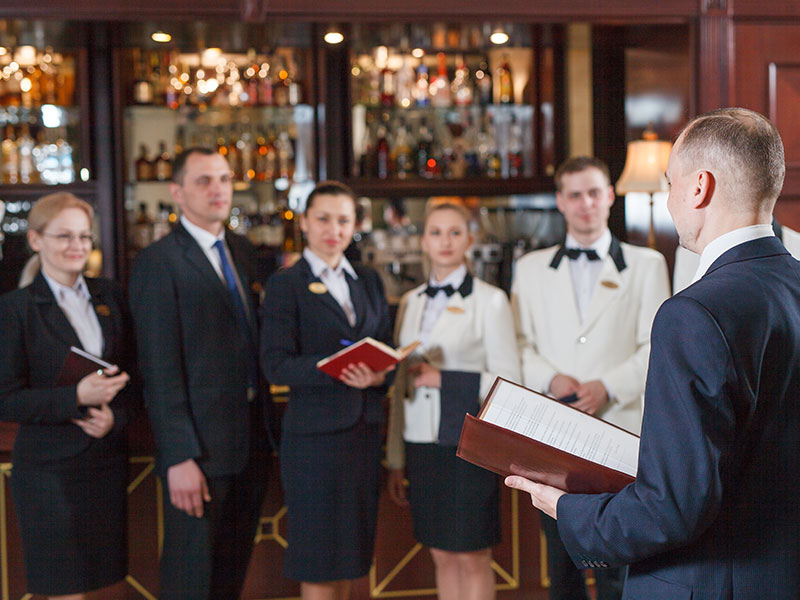 resturant staff getting talked to by man in a suit