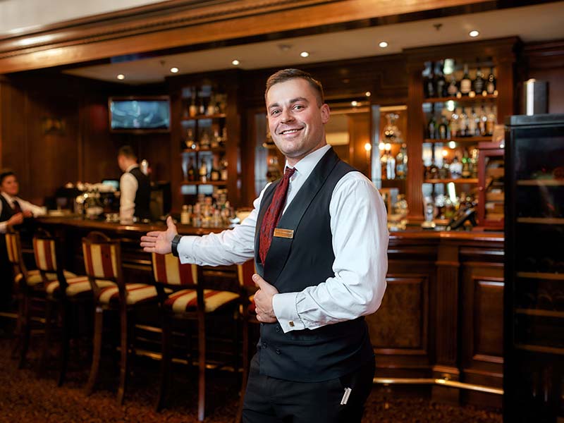 host seating guests at a bar